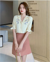 Blusa de oficina amarilla con bordado floral y manga corta